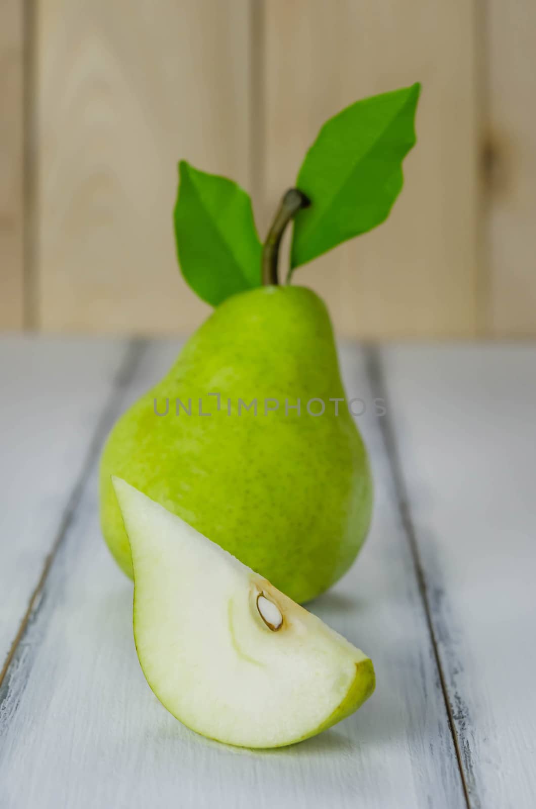 One and a slice green pears over white background
