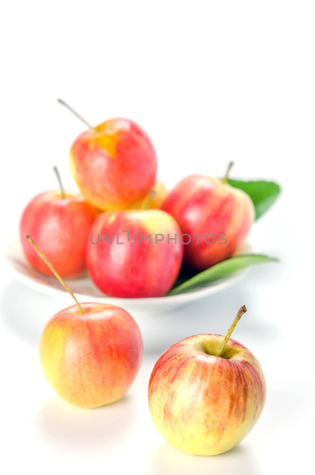 Red and yellow apple with white bowl , organic fresh fruit