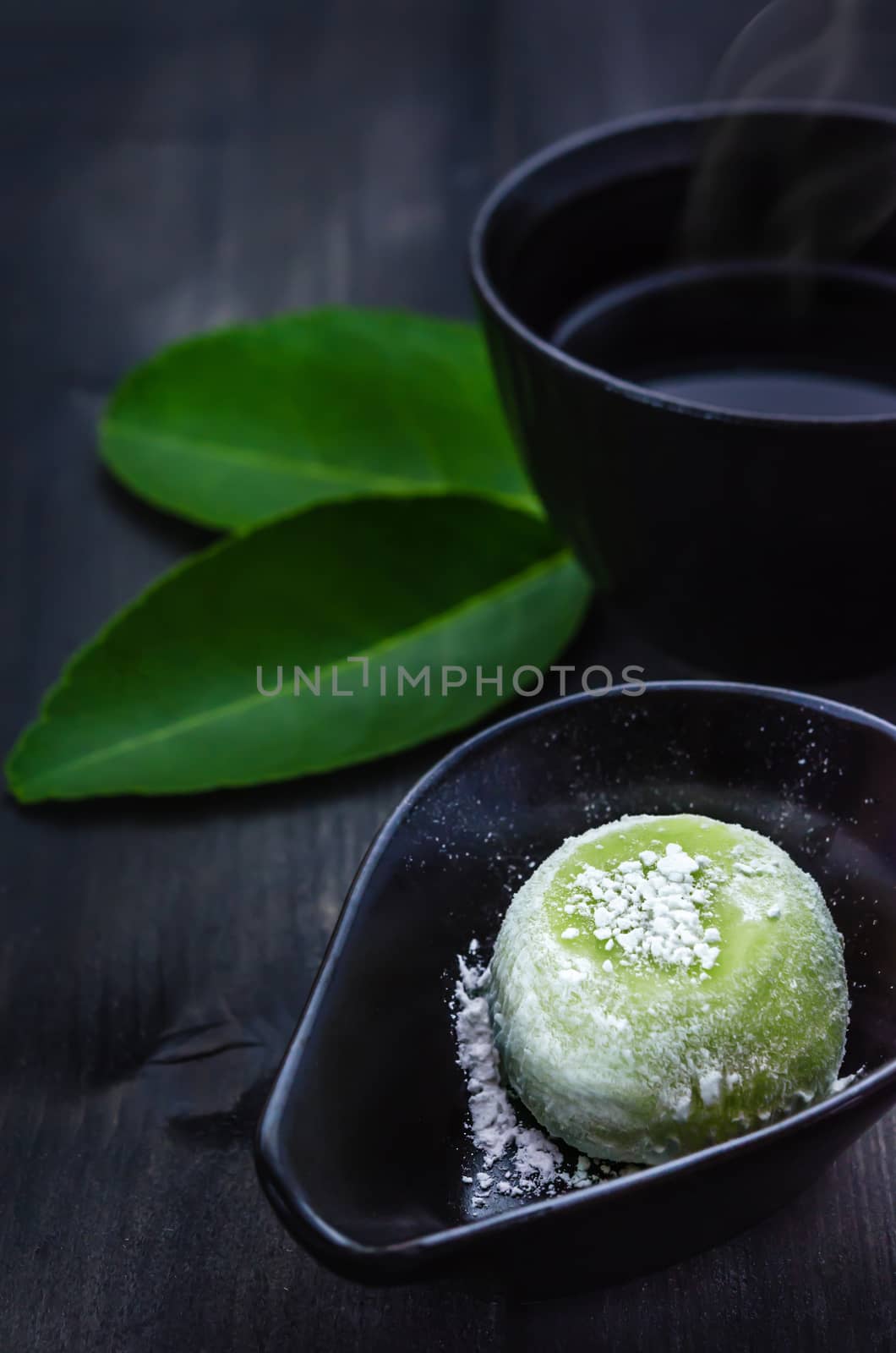 Green Daifuku Mochi Japanese dessert on dish served with  hot tea , still life