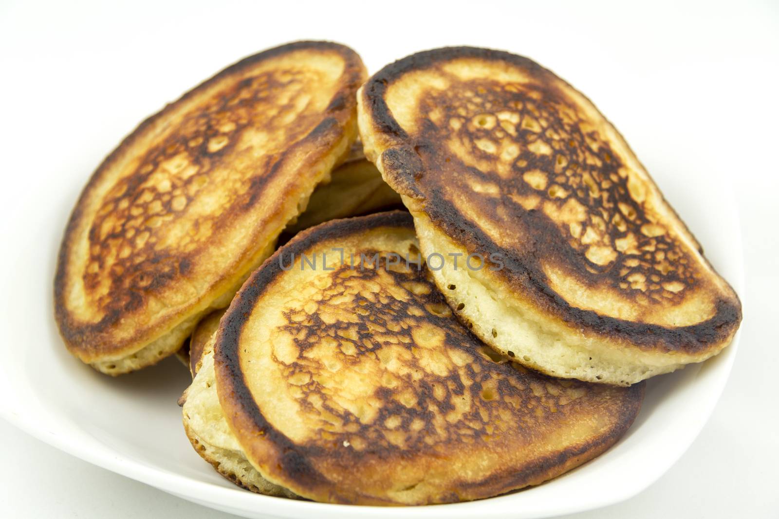 Closeup delicious curvy thick pancakes on a white plate