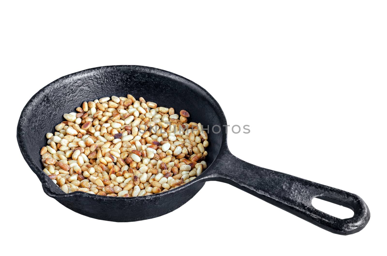Toasted pine nuts on an old cast iron frying pan, isolated on white background