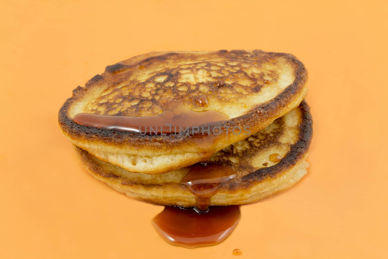 Pancakes with honey on a yellow background. by sergeizubkov64