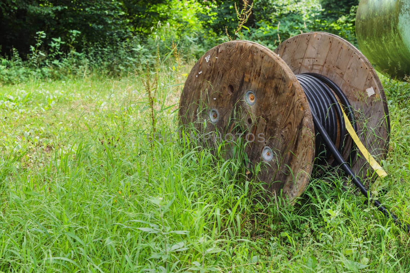 Cable drum, large industrial cable reel with a black fiberglass cable.