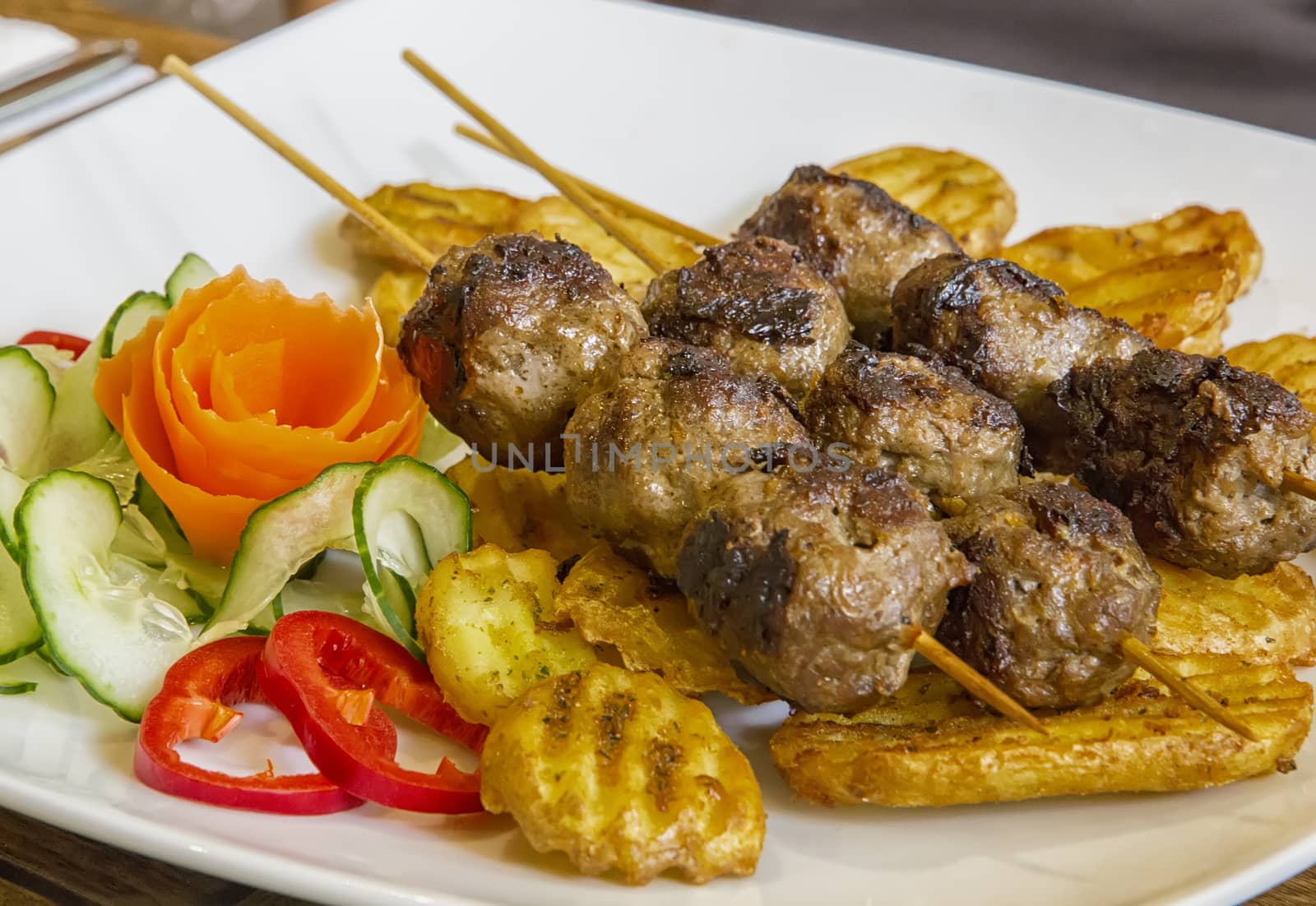 Grilled meat skewers with garnish, close up view