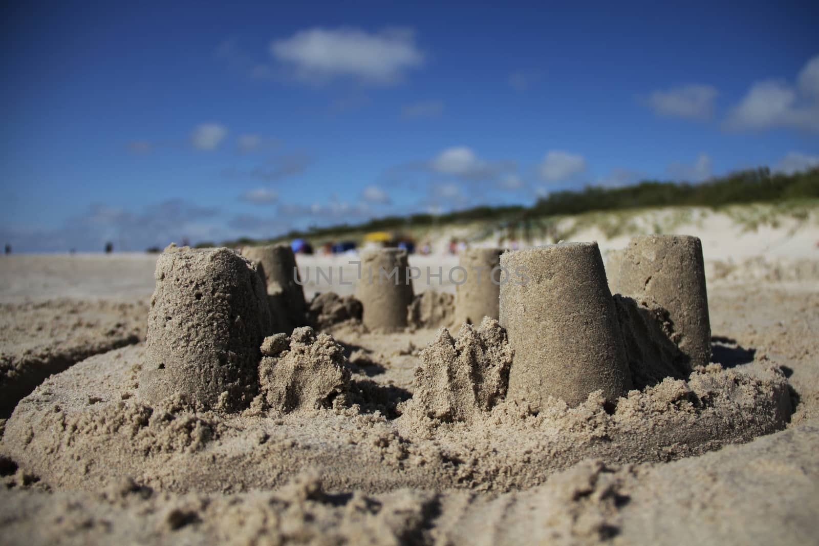 Sand castle on the beach with blue sky background