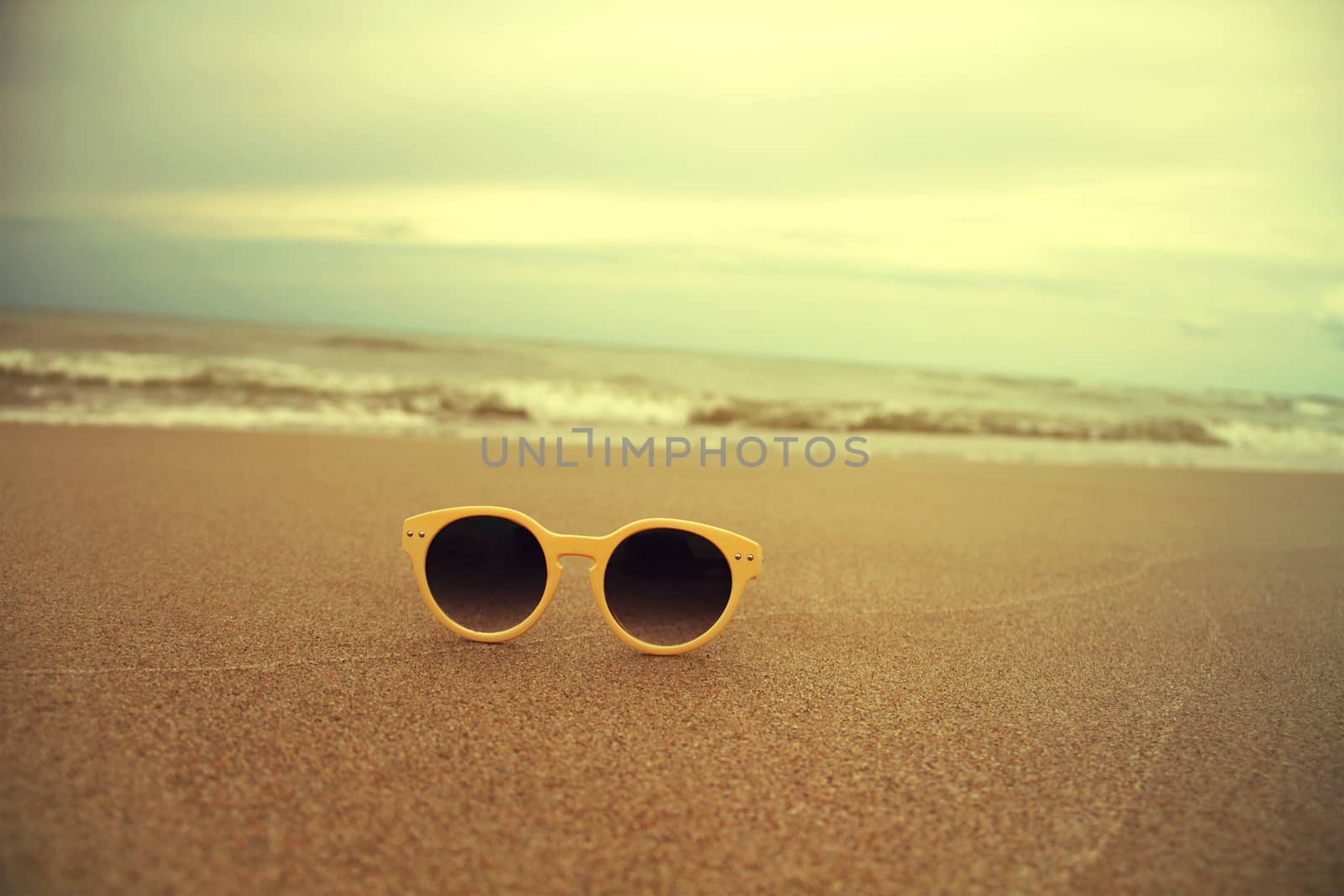 Sunglasses on the sand near beach beautiful summer photo in vintage style