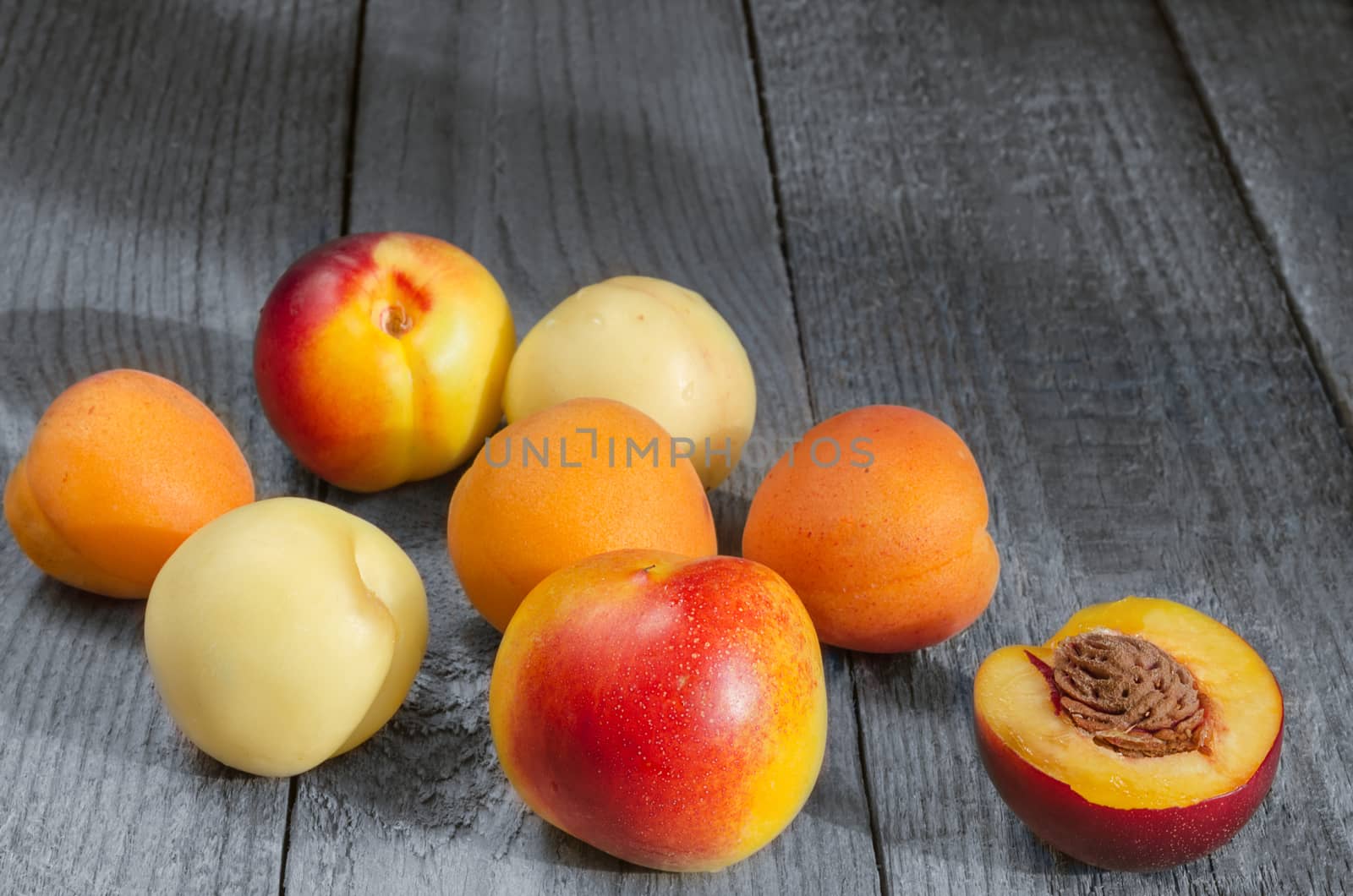 Southern fruit, apricots and nectarines on a gray wooden background