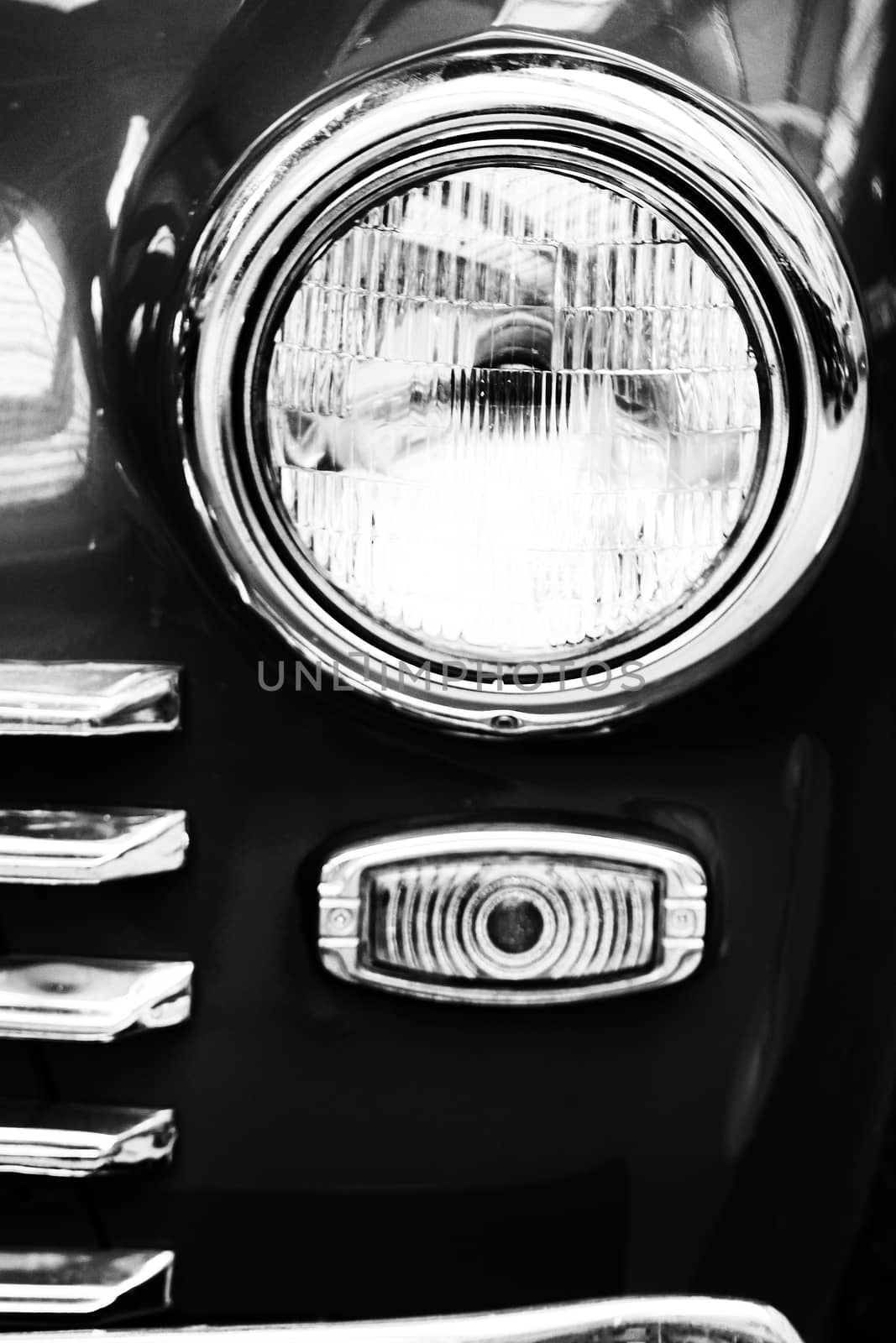 Retro car headlight close up photo. Right headlamp of old car black and white