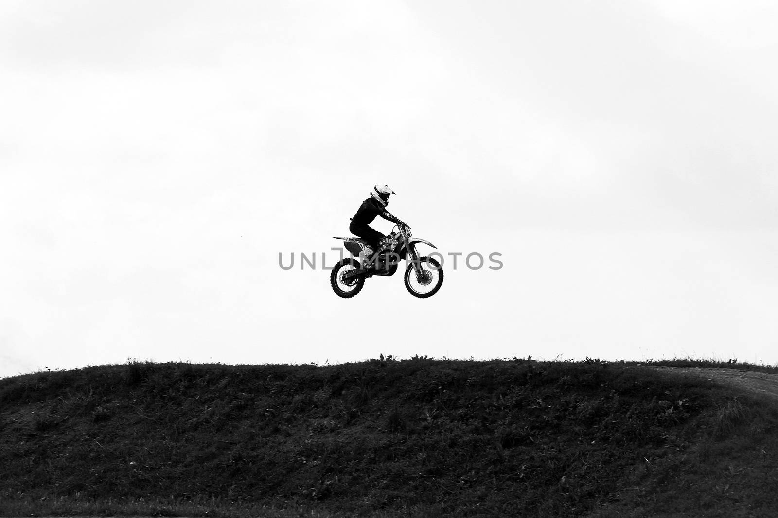 Motorbike jumping in the sky on hide speed black and white photo