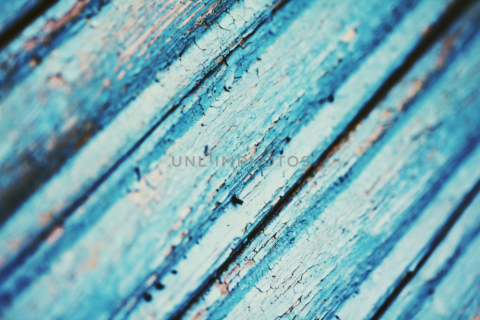 Cracked paint on blue wooden surface close up photo