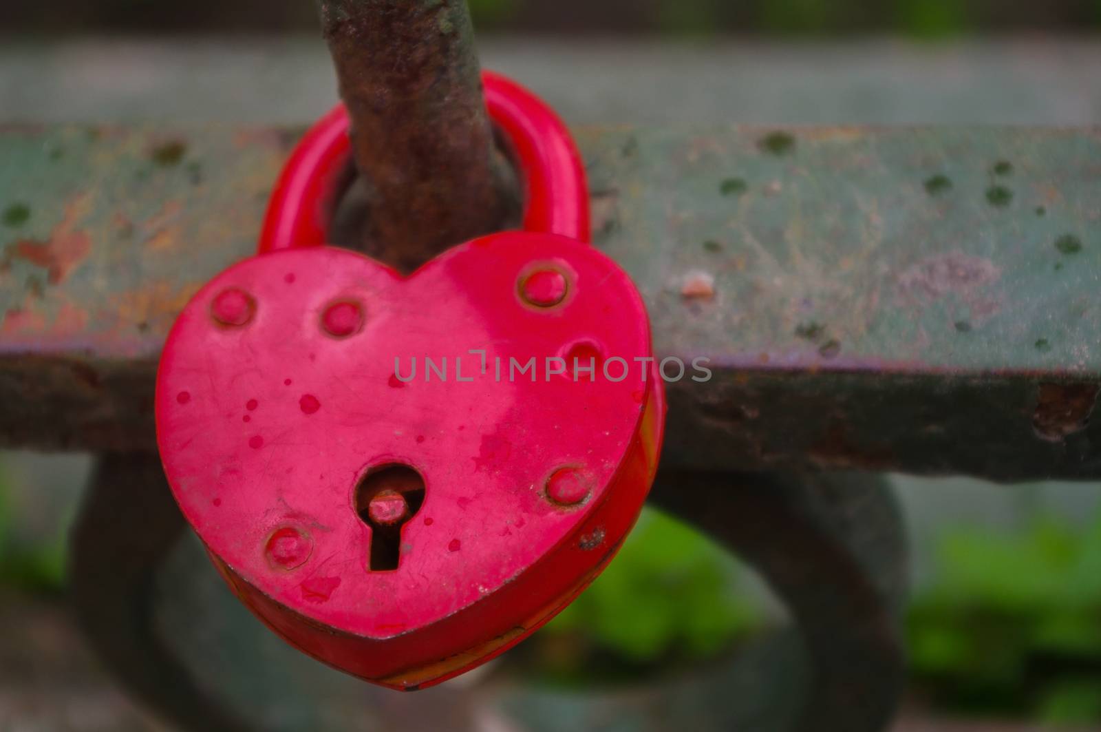 beautiful red heart-shaped padlock locked on iron chain by evolutionnow