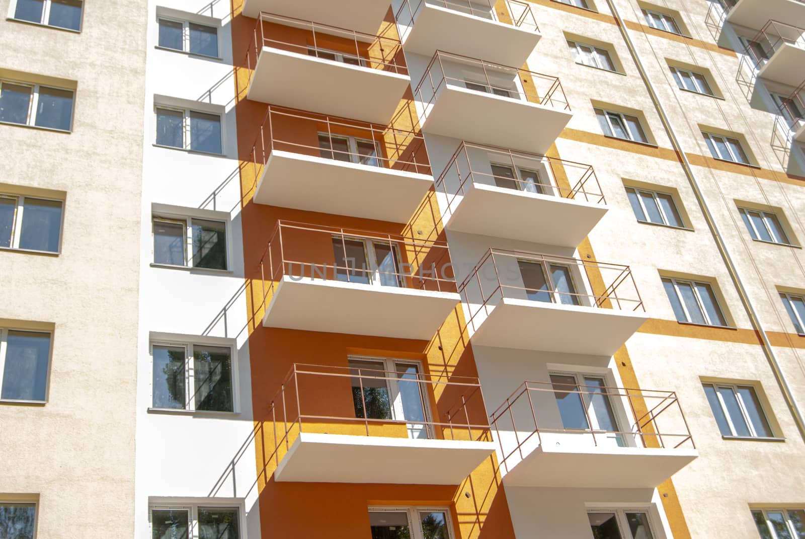 kind of new multistory residential building decorated in orange and yellow colors in sunny day