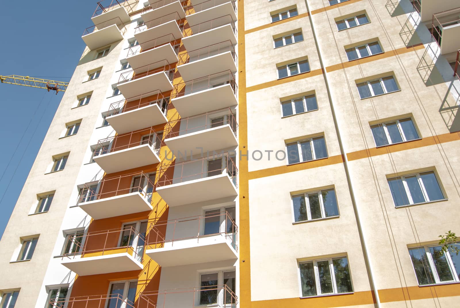 kind of new multistory residential building decorated in orange and yellow colors in sunny day