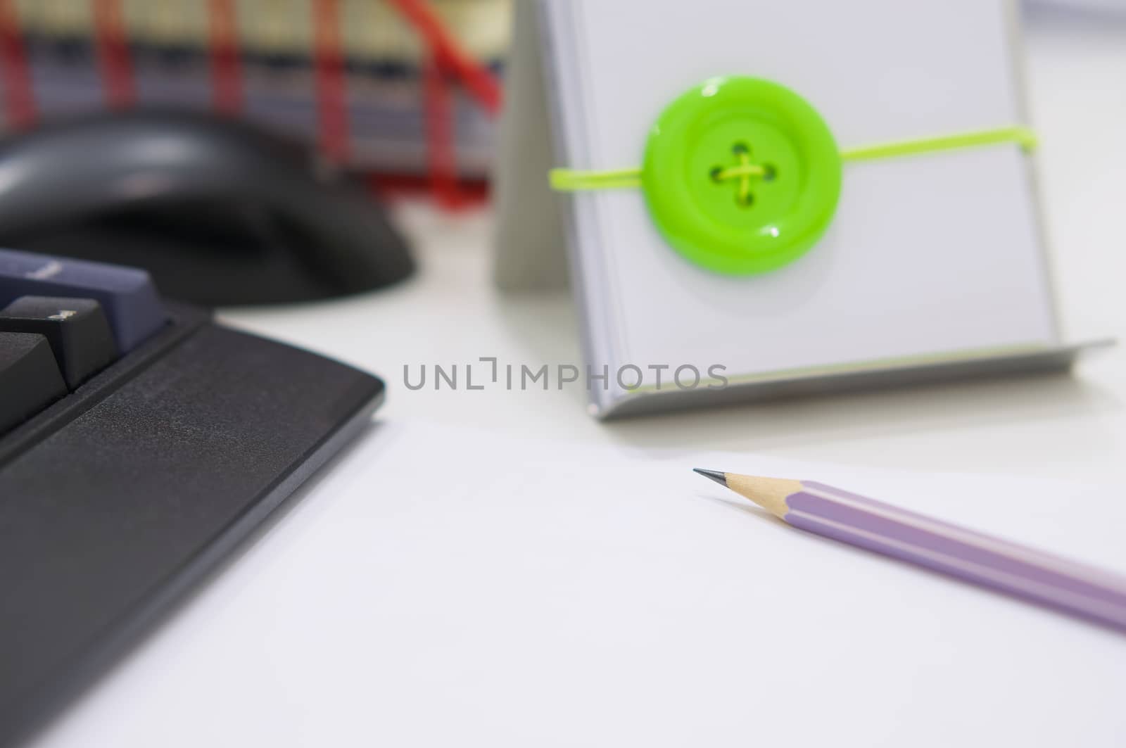 Black computer and office supplies on white table at workplace.