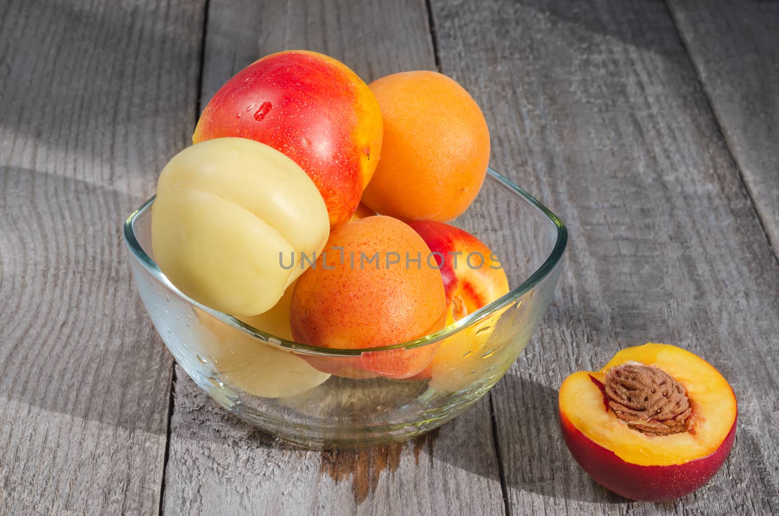 Southern fruit apricots and nectarines, in a vase on a gray wooden background