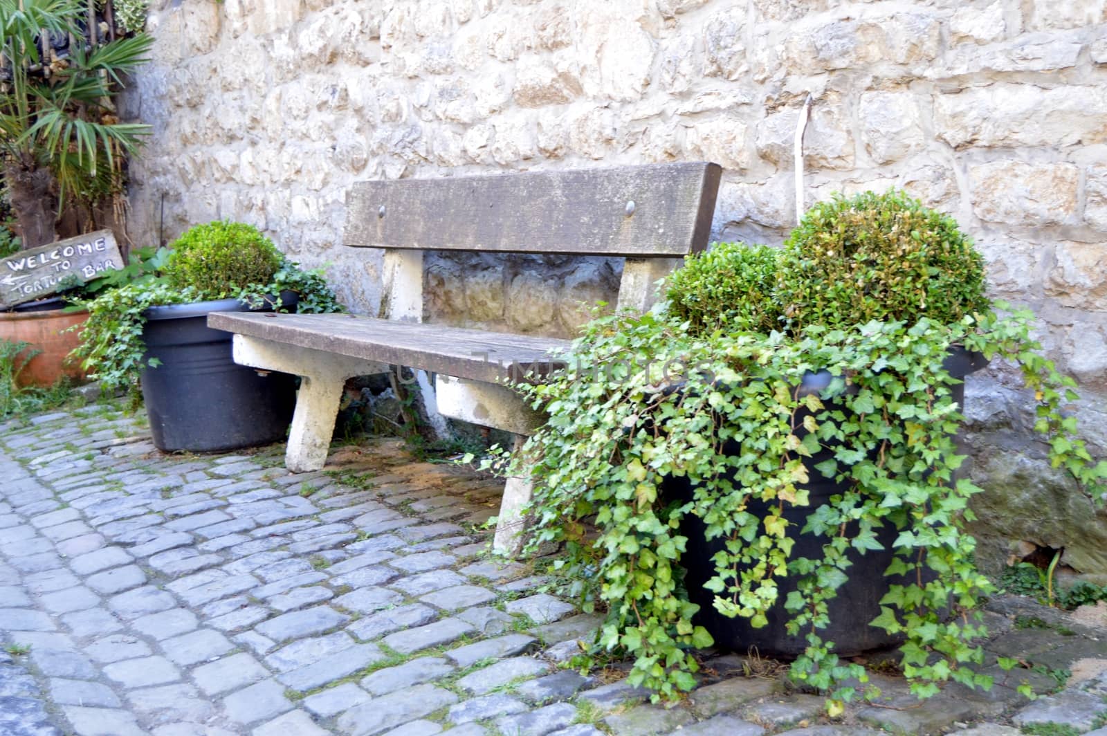 Bench in lamellas of brown wood in a wooden corner.