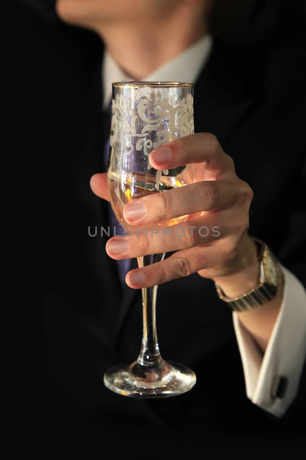 Glass of champagne in a hand of the groom