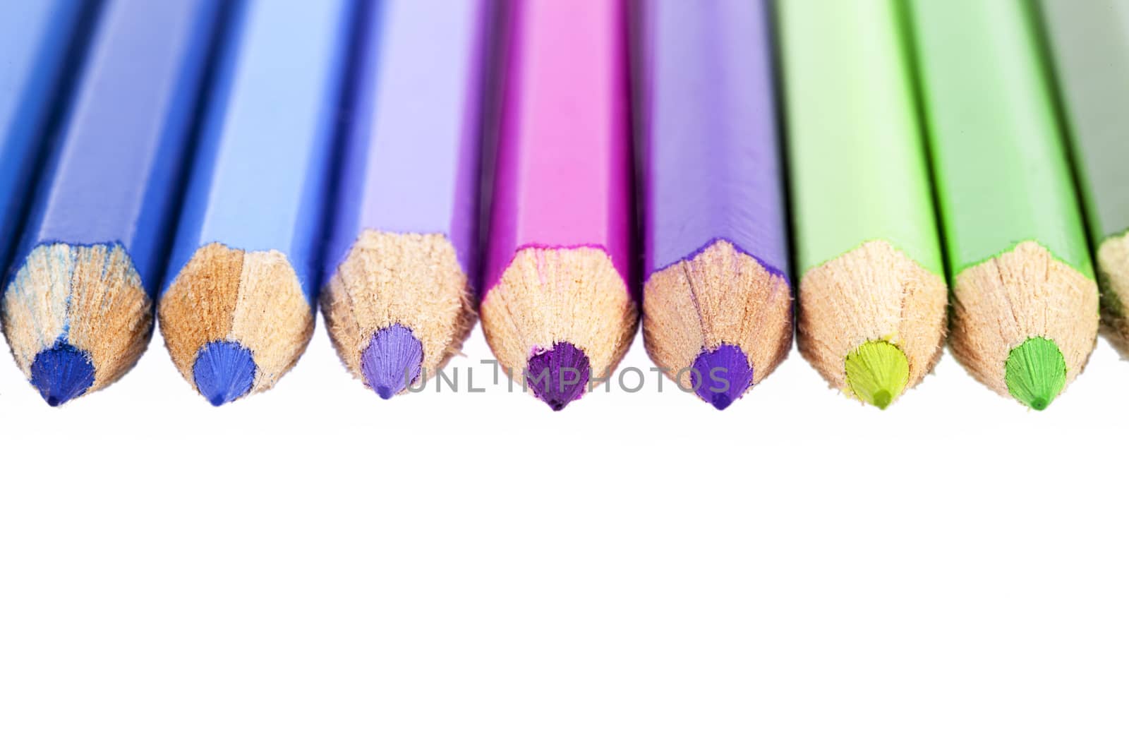 Chipped colored crayons on white background, close up