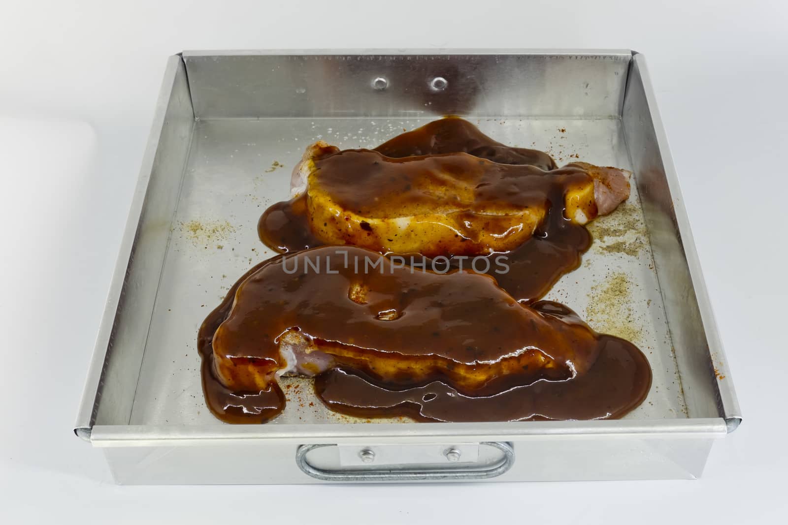 Raw pork fillet with barbecue sauce in baking tin by art9858