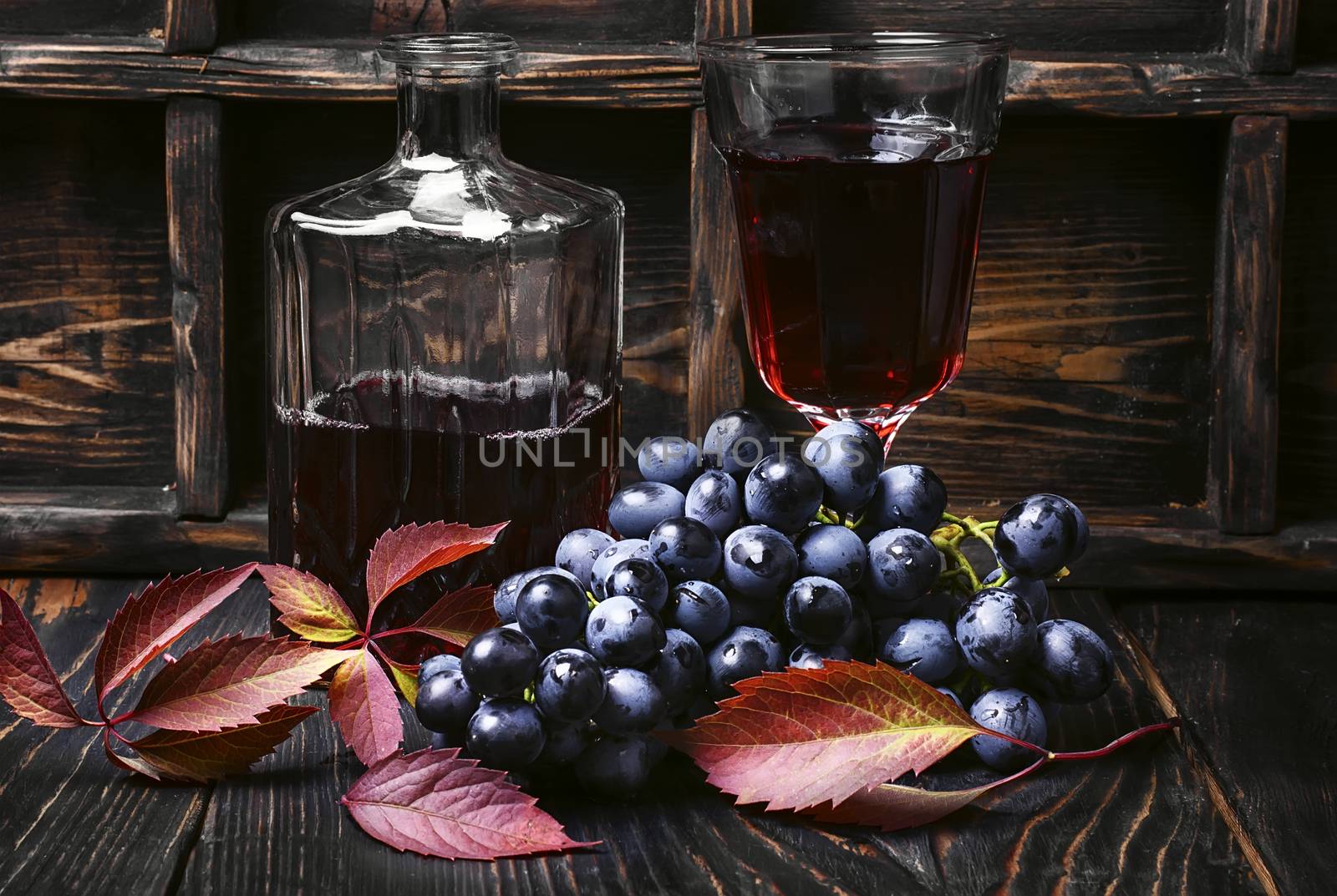 Young red wine in the glass from the autumn harvest of grapes.Dark key