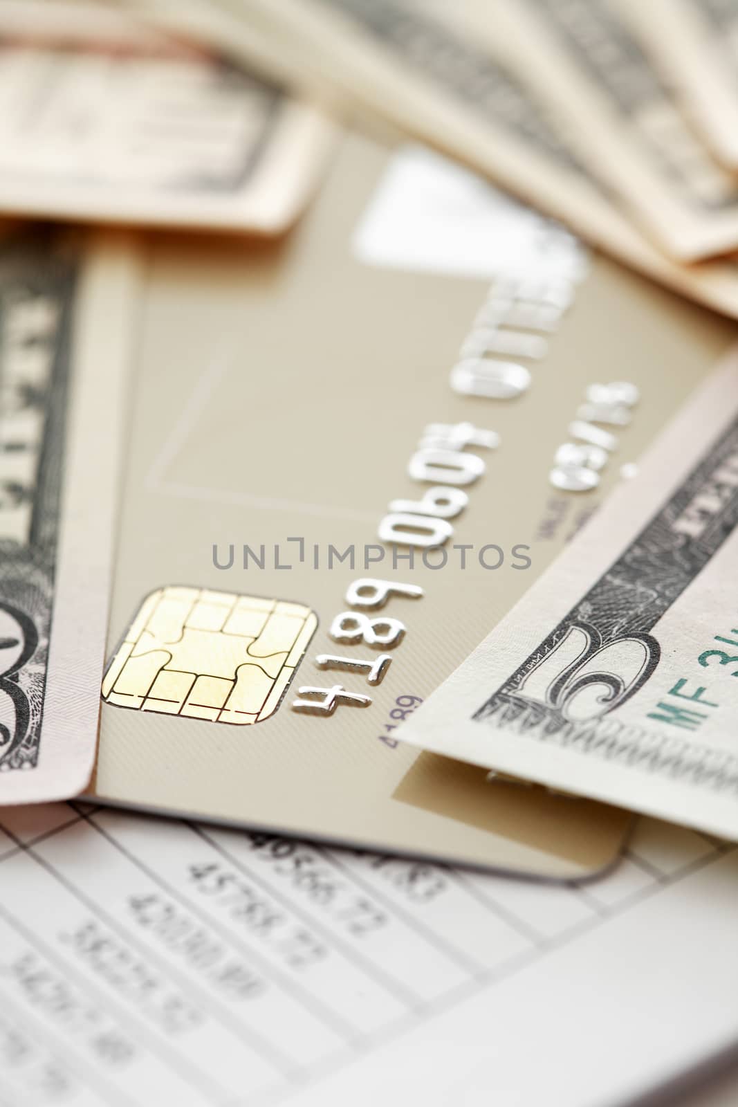 Credit card near money on paper background with digits