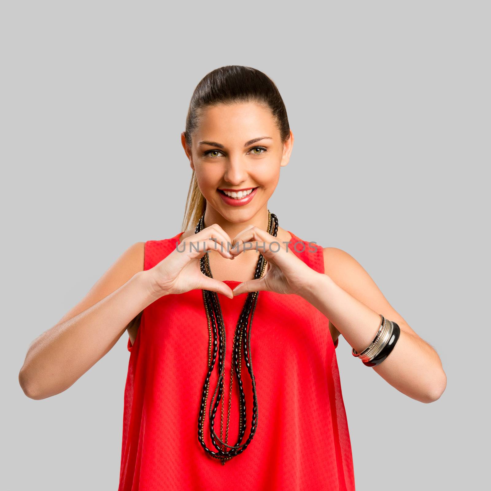 Portrait of a beautiful woman making the heart shape with her hands
