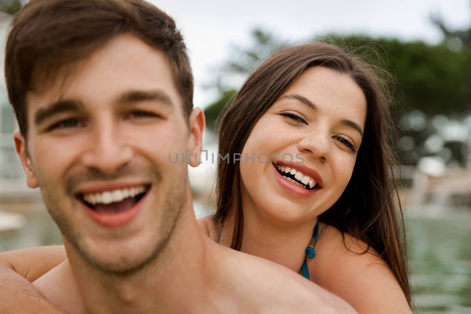 Portrait of a young couple embraced inside the pool