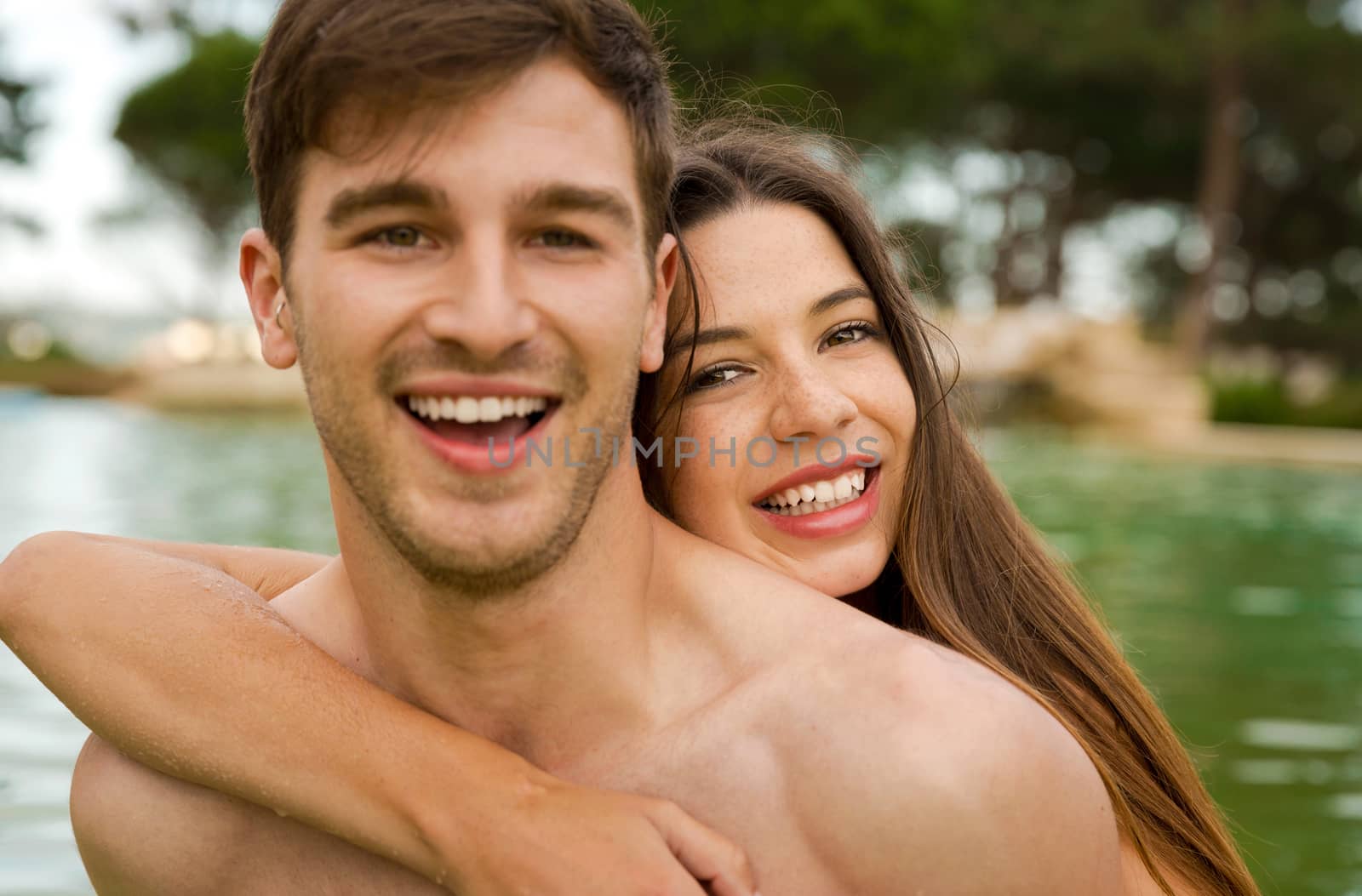 Portrait of a young couple embraced inside the pool