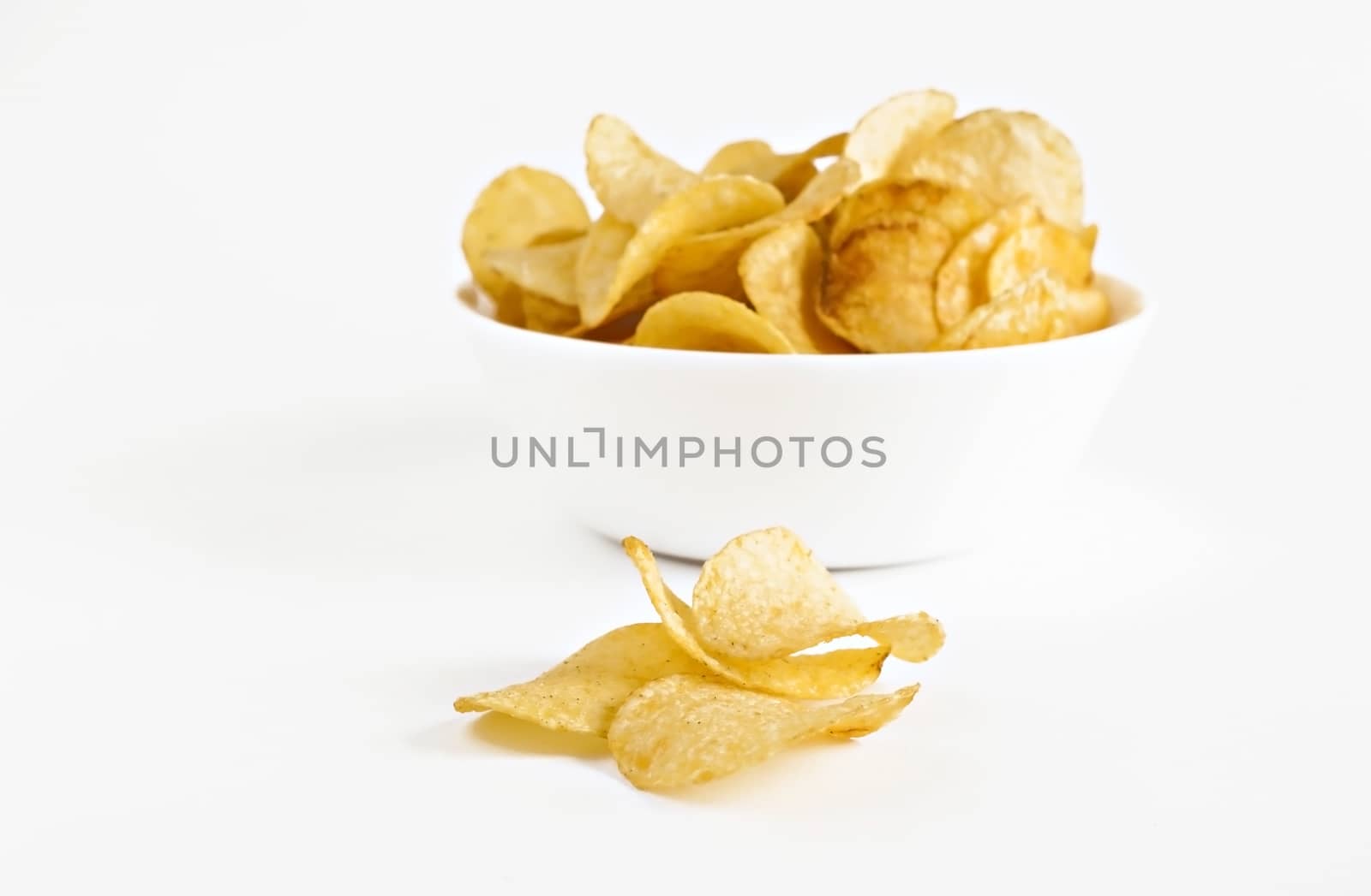 potato chips in a white dish isolated.