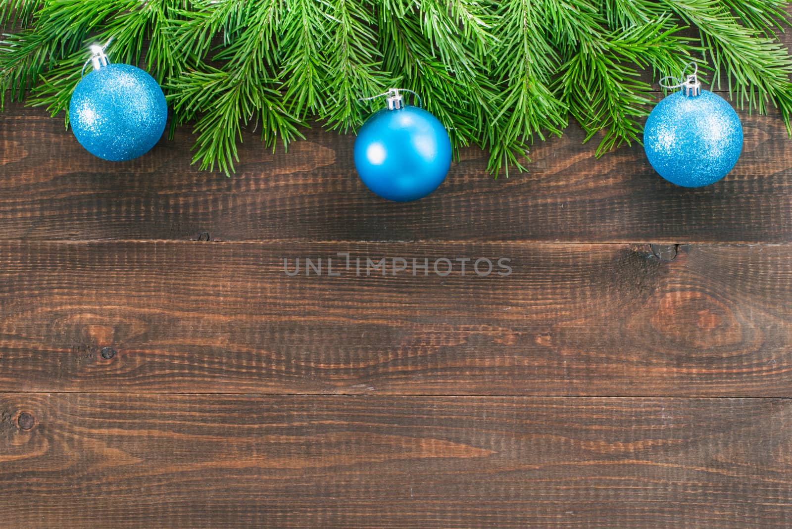 Christmas fir tree with decoration on dark wooden board background. Border art design with Christmas tree and blue baubles. Xmas and new year concept with copy space