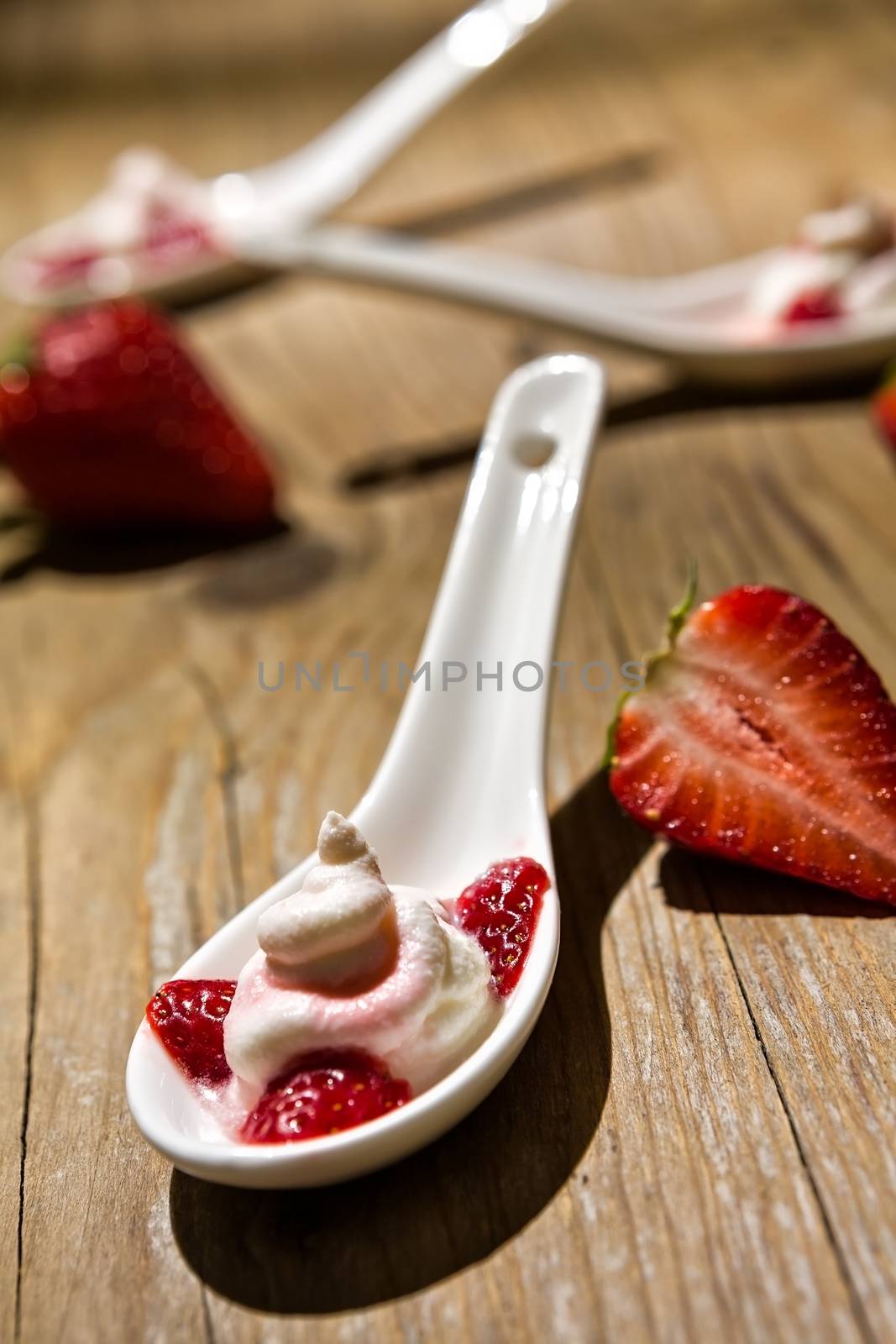 Close up of a mascarpone cheese and strawberries on wooden background