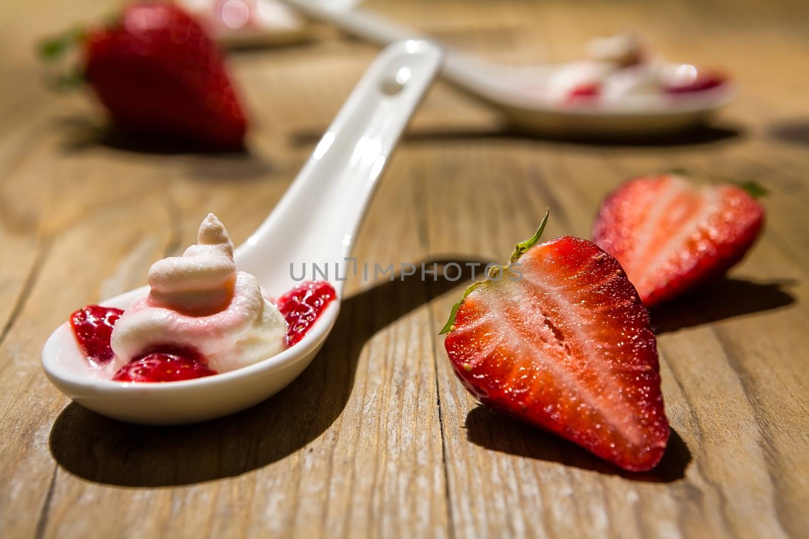 Close up of a mascarpone cream and strawberries on wooden background