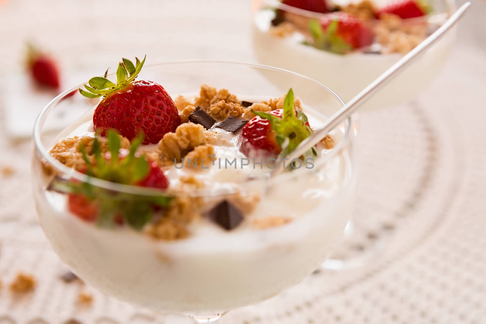 Close up of dessert with strawberries cereals chocolate flakes and yogurt