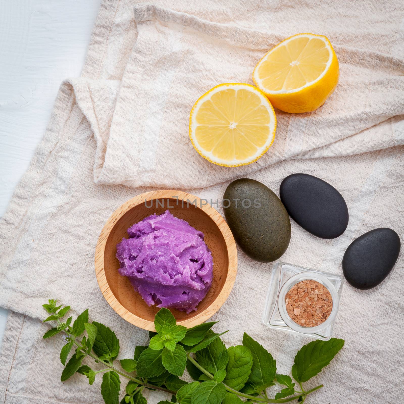 Alternative skin care lavender scrubs with natural ingredients lemon slice ,peppermint and aromatic oils set up on white wooden background with flat lay.