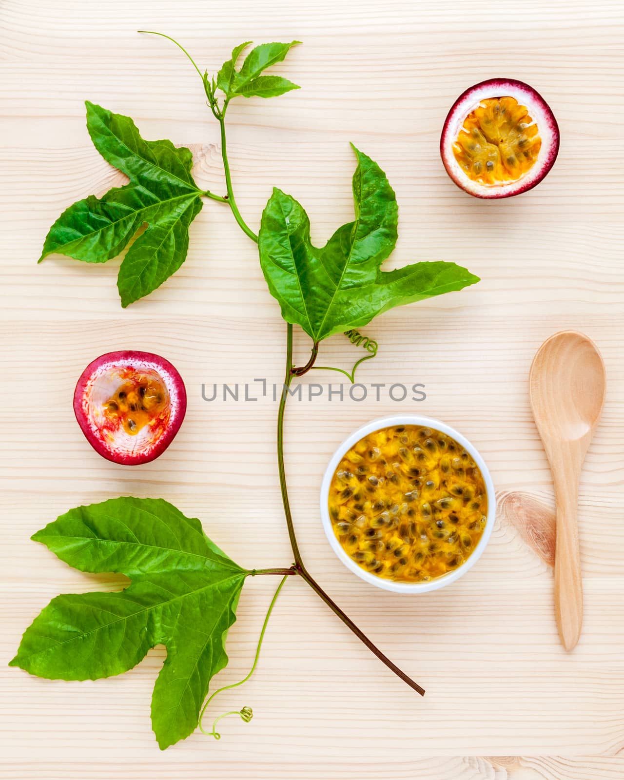 Fresh passion fruits set up on wooden background. Juicy passion fruits with green leaves  and Passion fruit vine flat lay .