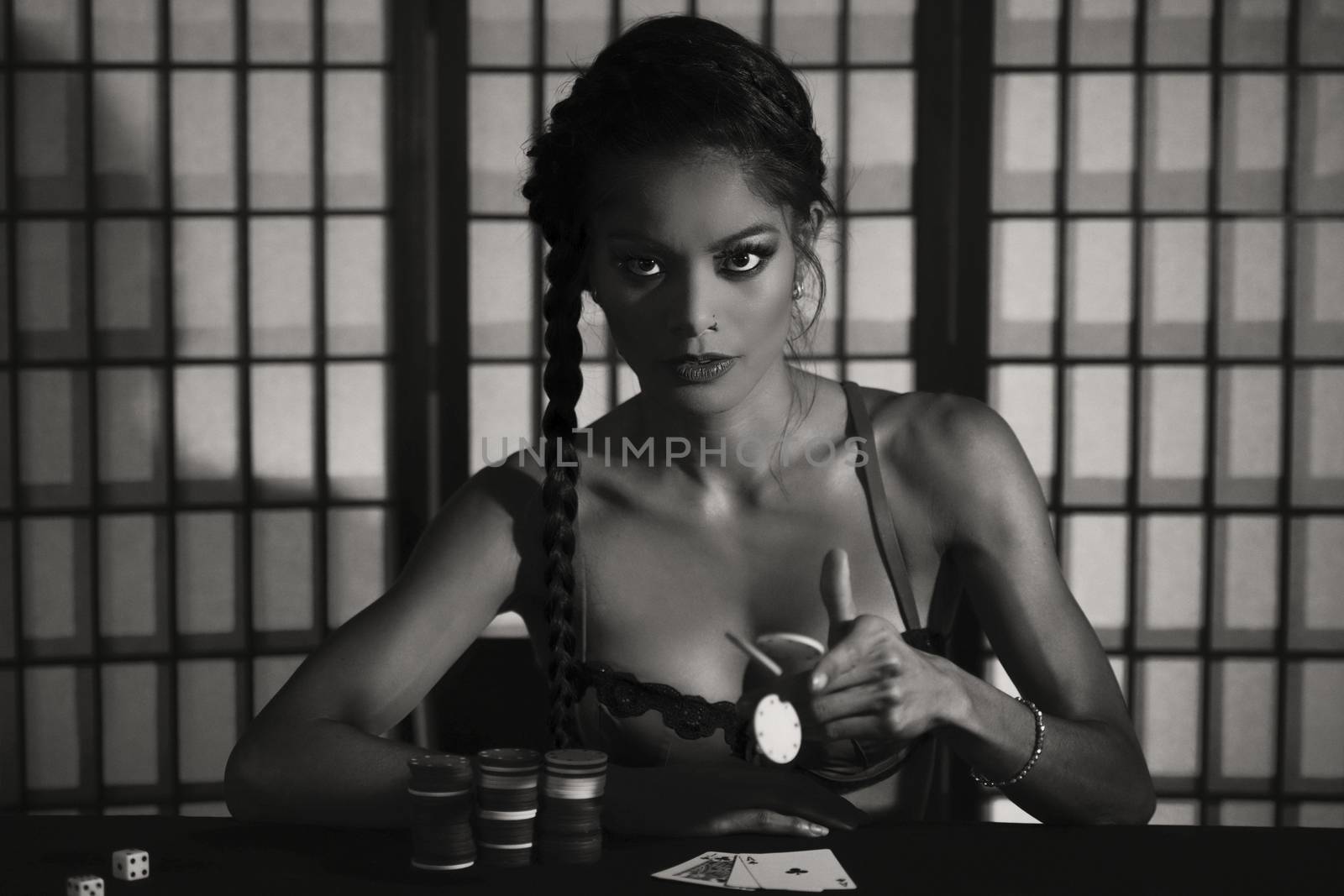 Concept: A beautiful high stakes poker player is winning big and feeling sensual and confident. Cinematic portrait. Black and white image.
