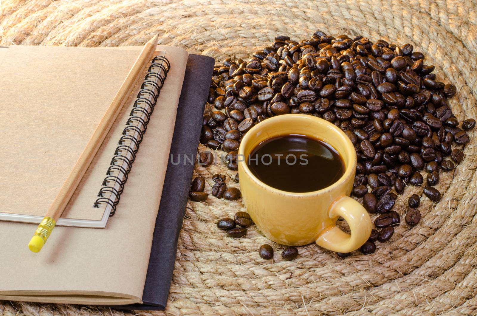 Cup of coffee with  notebook on a jute rope.