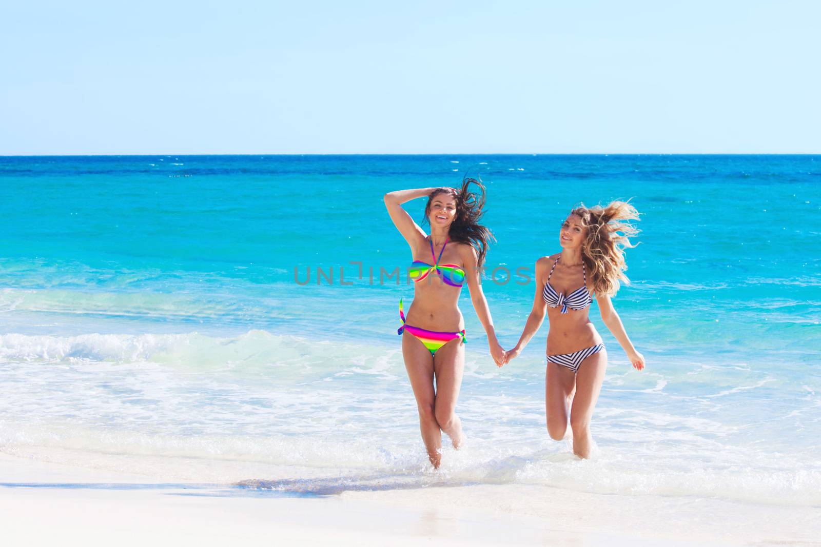 Happy smiling female friends in bikini on vacation
