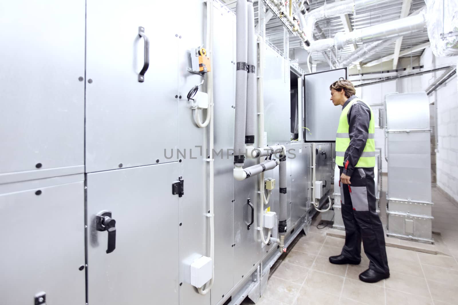 Worker in electrical switchgear room of CNC plant