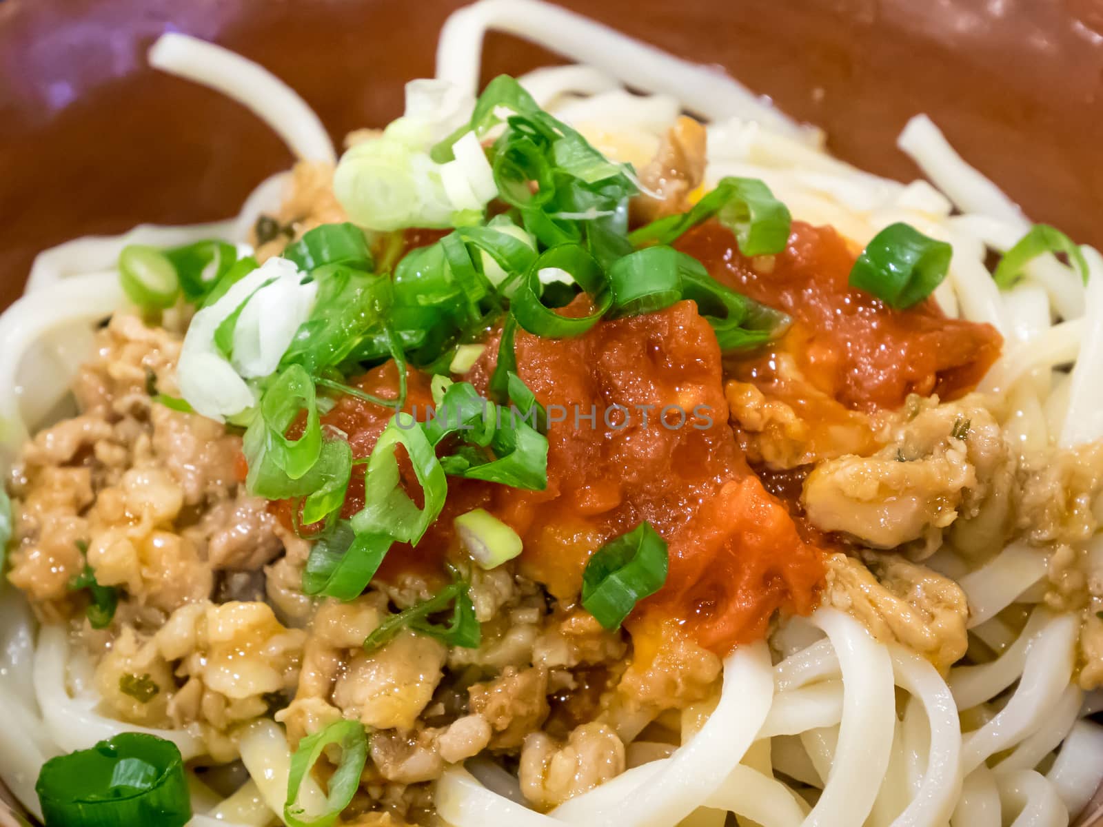 The close up of tasty tomato sauce dry noodles with minced pork.
