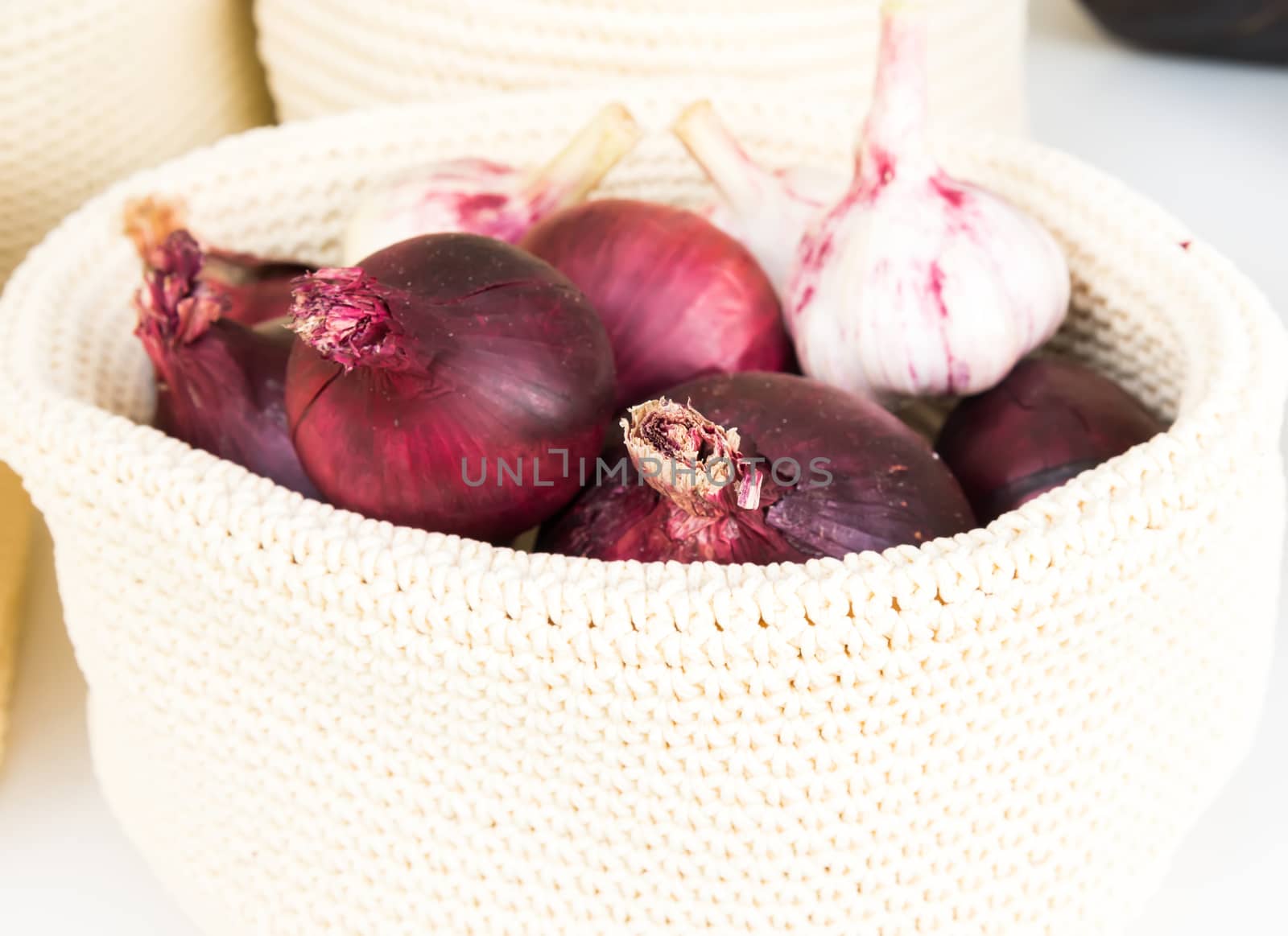 red onions in a wicker basket close-up by vlaru