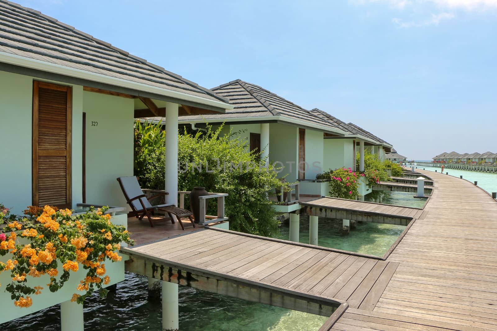 row of water bungalows on a tropical island - travel background by evolutionnow