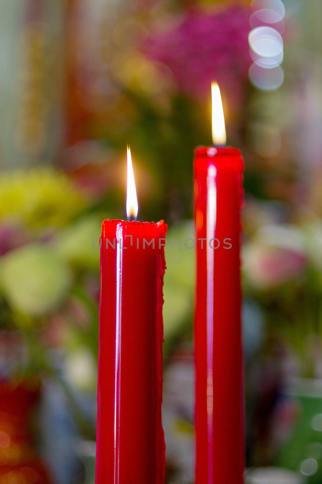 many prayer red burning long candles in budist temple