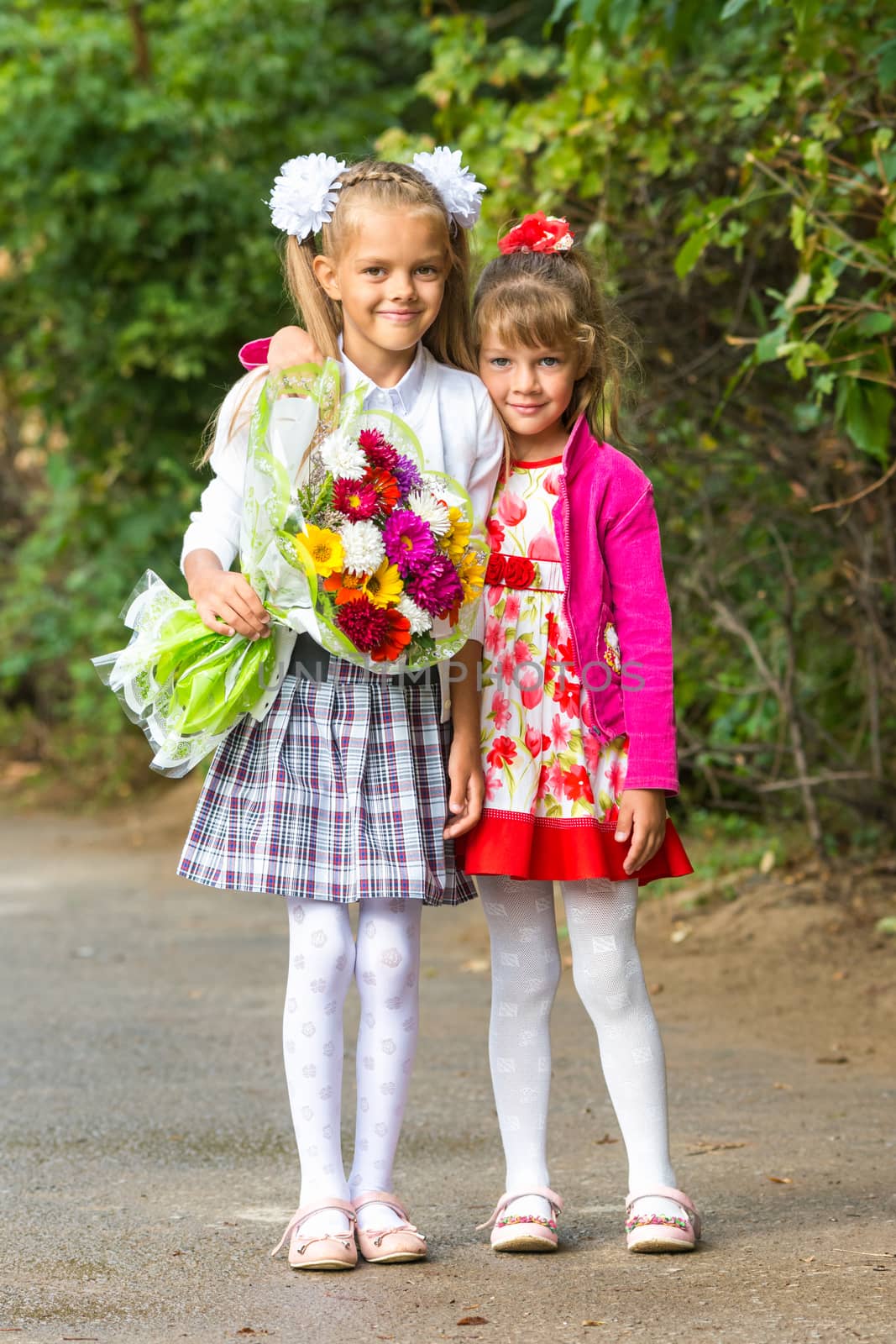 Portrait first grader and her younger sister on the way to school