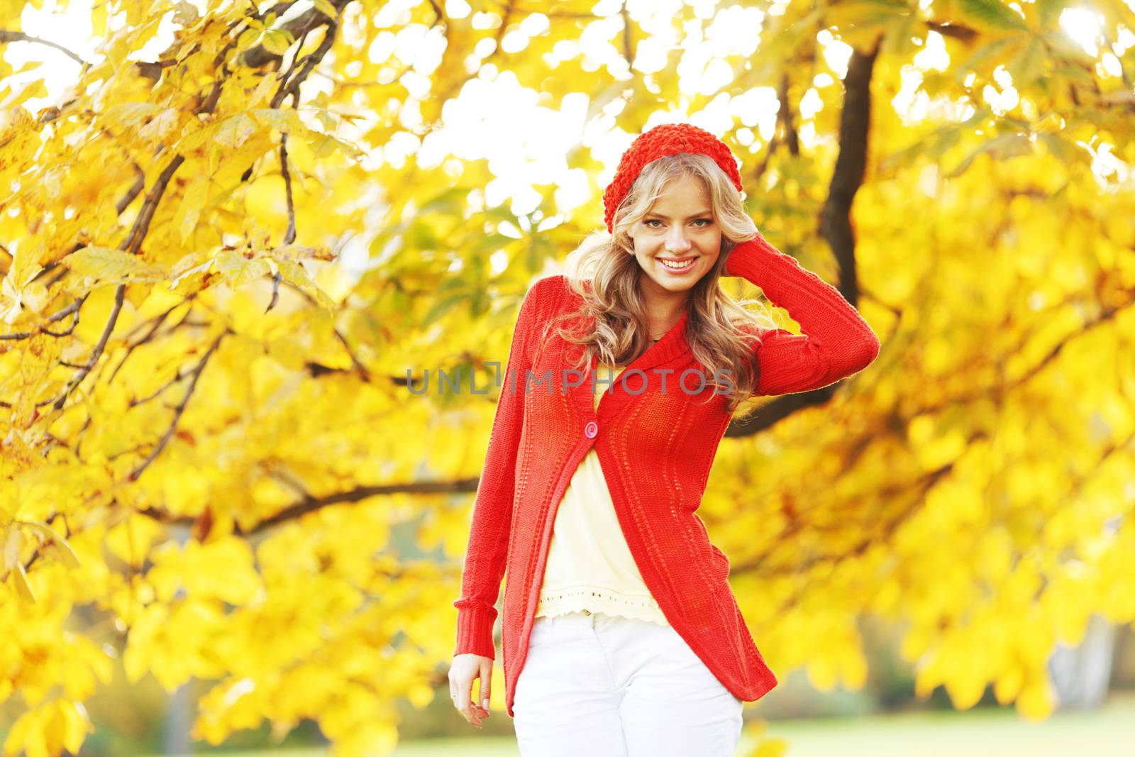 Beautiful young woman in red clothes in autrumn park