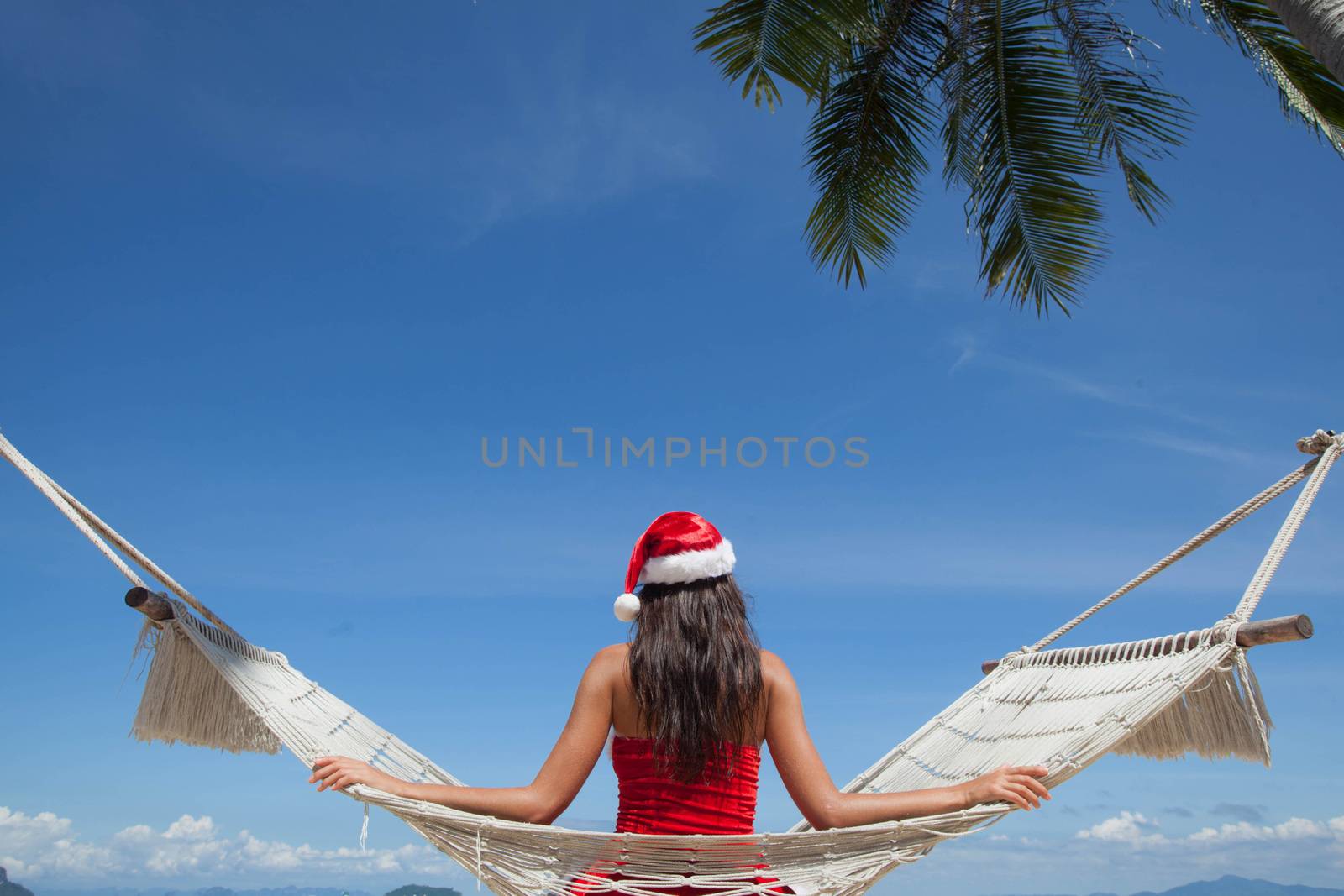 Woman in hammock on tropical beach celebrating Christmas