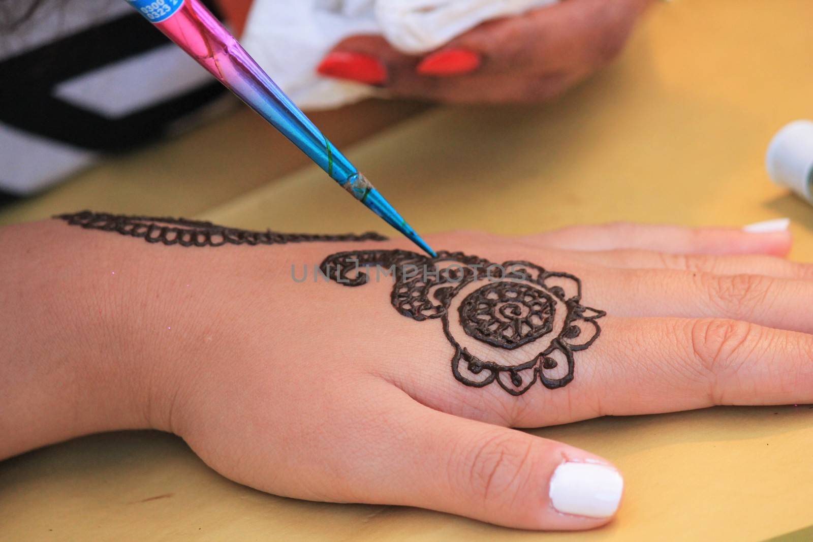 Indian Henna tattoo being applied to hand by cheekylorns