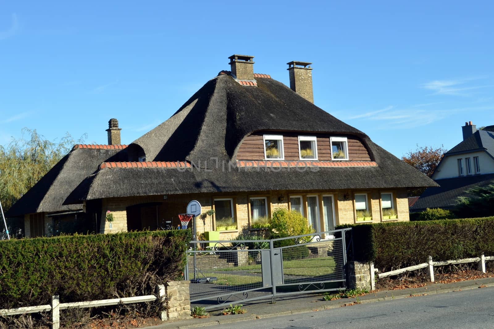 House in stones with a roof in thatch and oval curves.