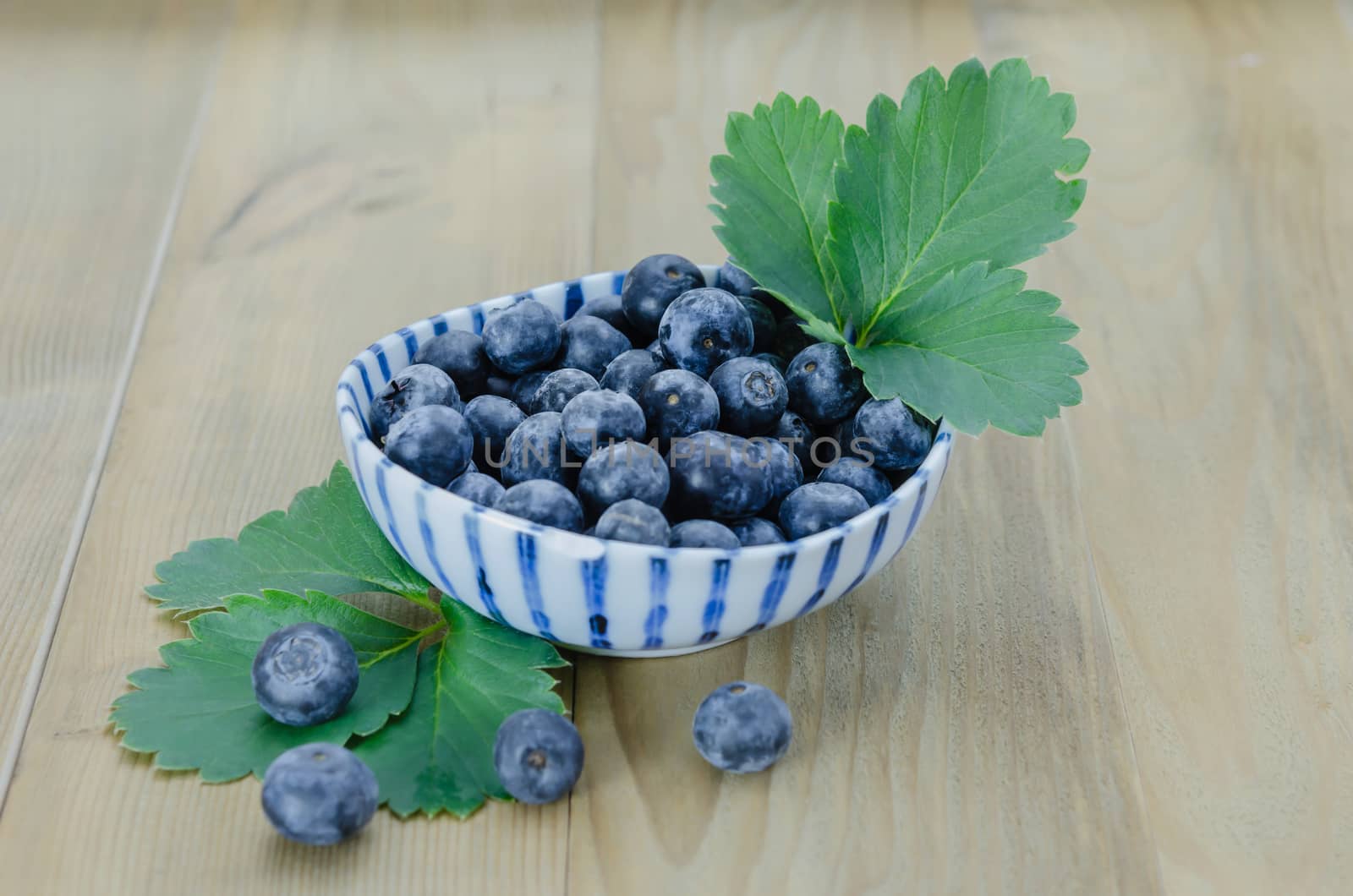 Blueberries in a bowl on a wooden background