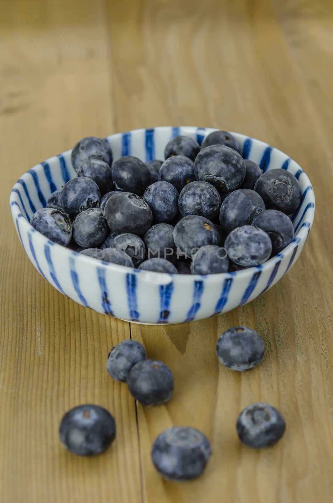 Blueberries in a bowl on a wooden background